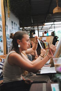 Women engaging in creative painting during an indoor art class workshop.